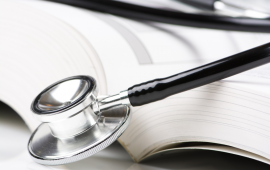 stethoscope laying on an open book